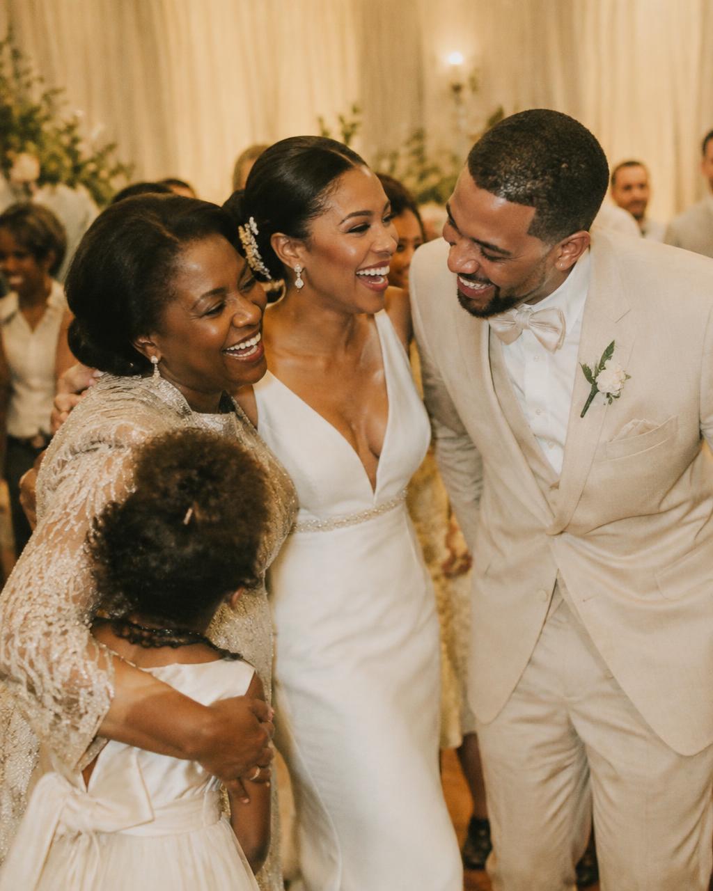 Bride and groom laughing with family on the dance floor